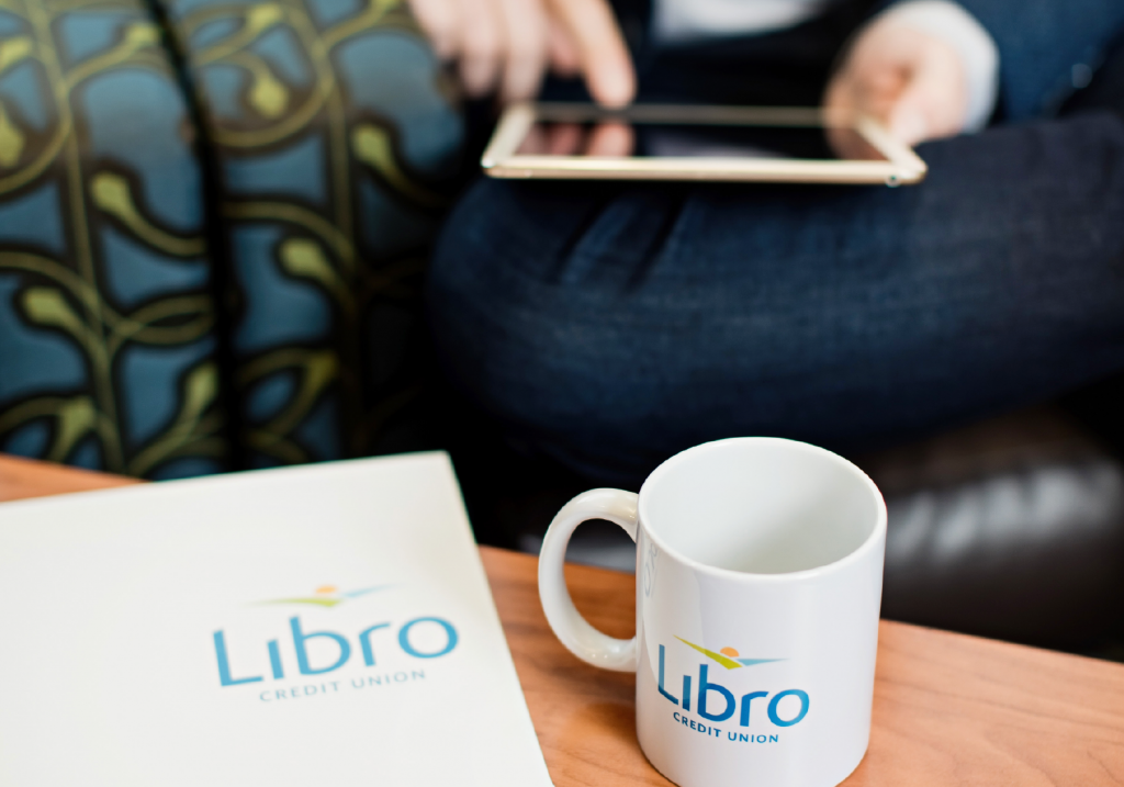 Libro mug and folder on table in front of iPad user