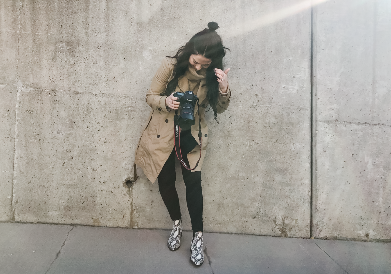 Woman standing and looking down at a camera