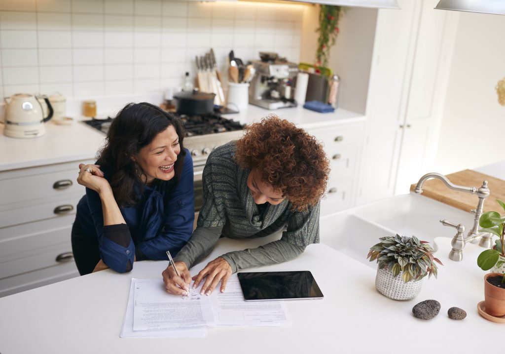 Two people talk and plan finances at the kitchen table