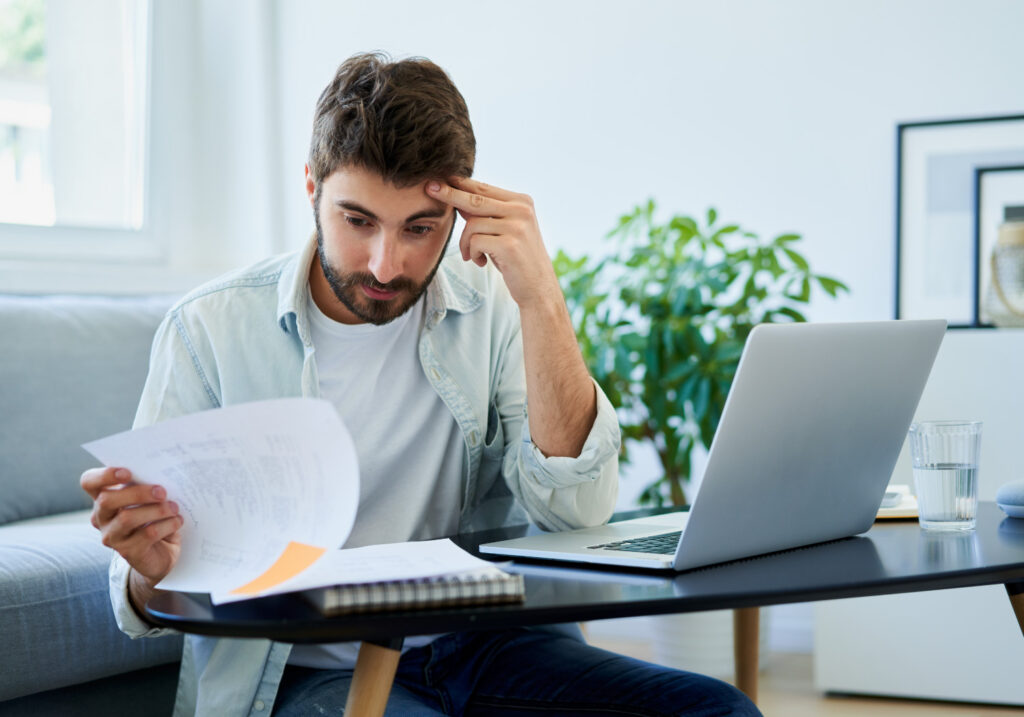 A man looking at his payday loan bills and asking how he is going to afford them