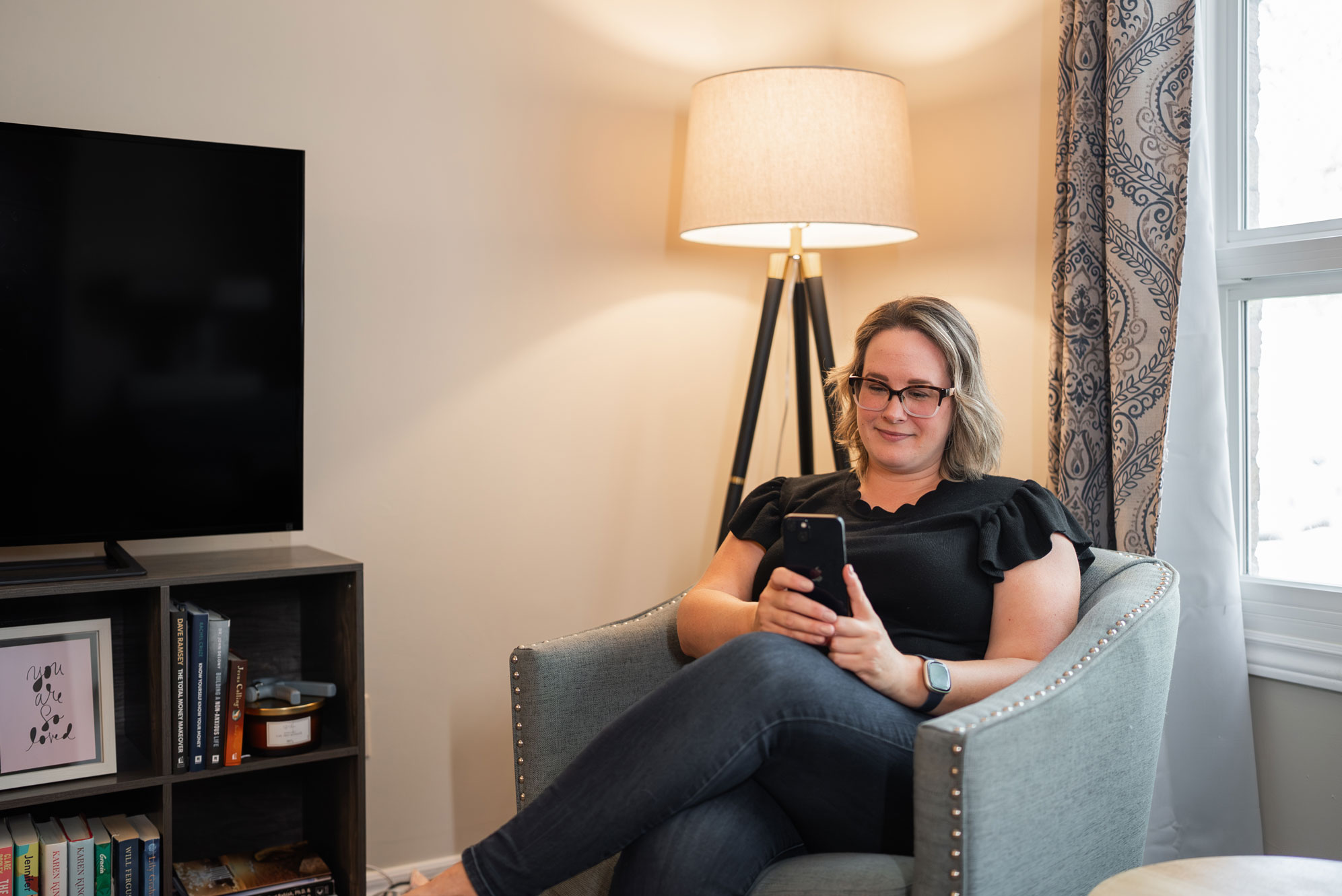 Libro Owner in her home, sitting on a chair looking at her phone