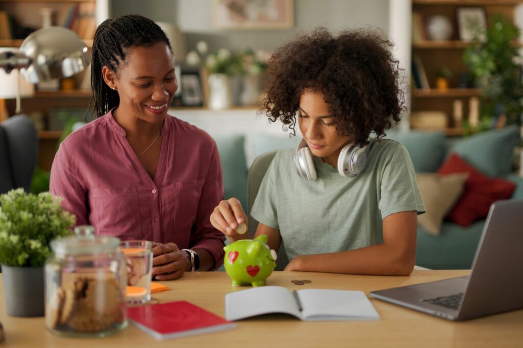 A mother an child learning about money with a laptop and piggy bank