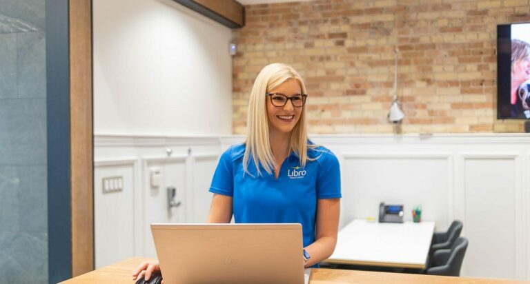 Libro Coach at a branch working on a laptop