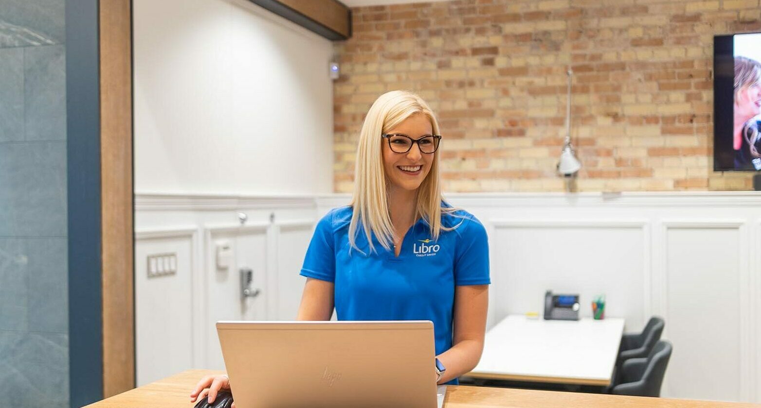Libro Coach at a branch working on a laptop
