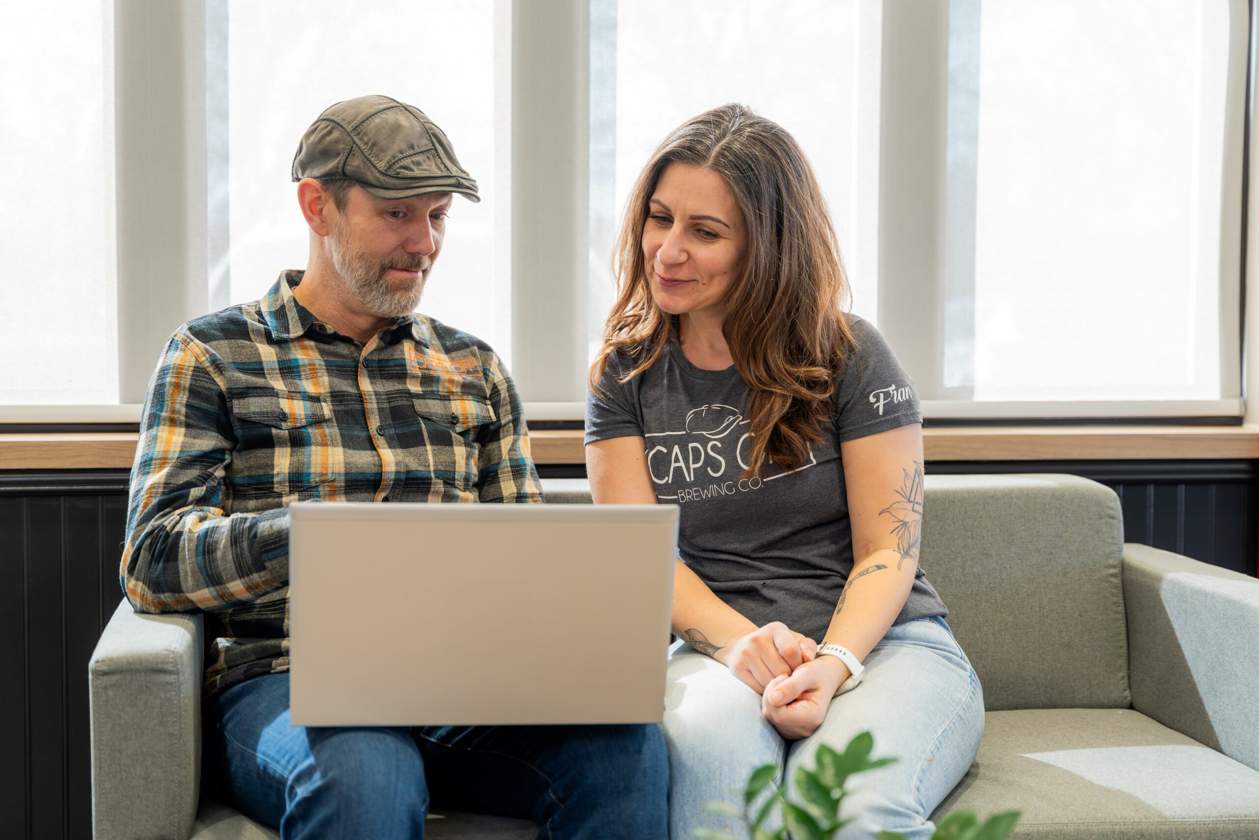 Libro Owners Caps Off Brewing sitting on a couch with a laptop