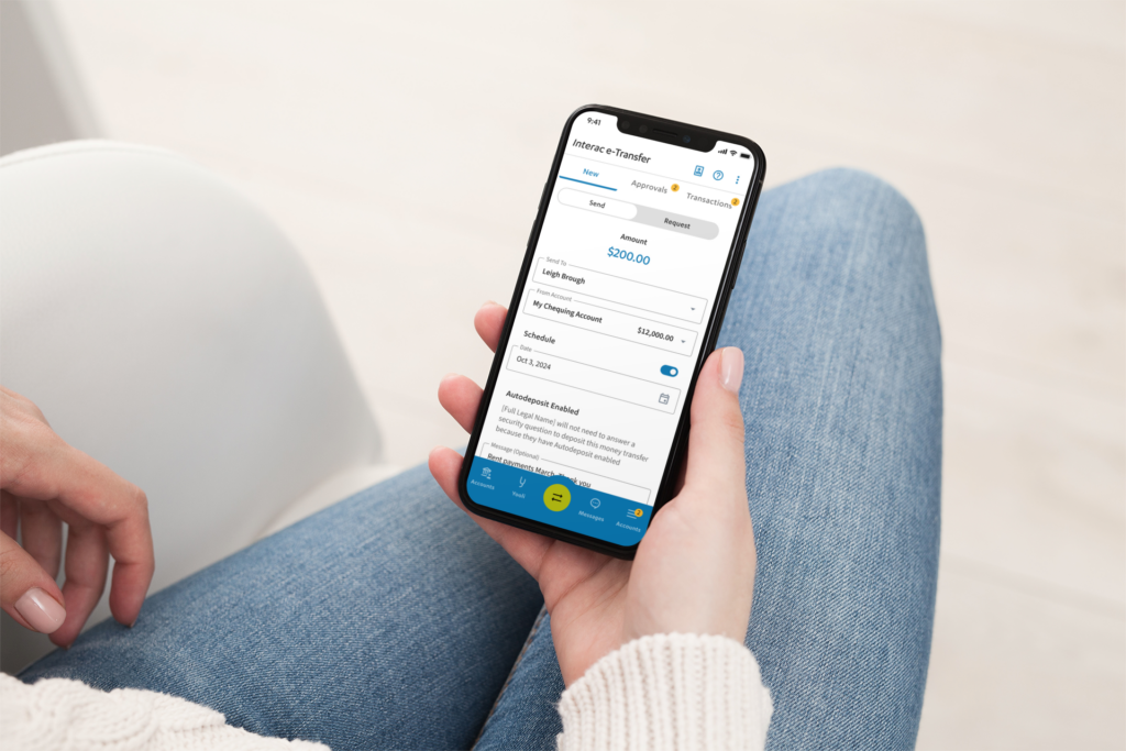 A person holding a smartphone displays a banking app screen showing account balance, transaction details, and options to send or request money.