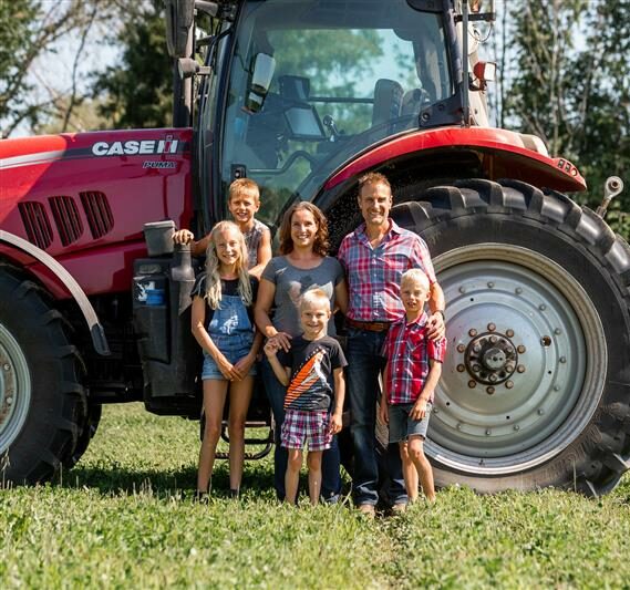 Libro Owners on their farm in front of a tractor