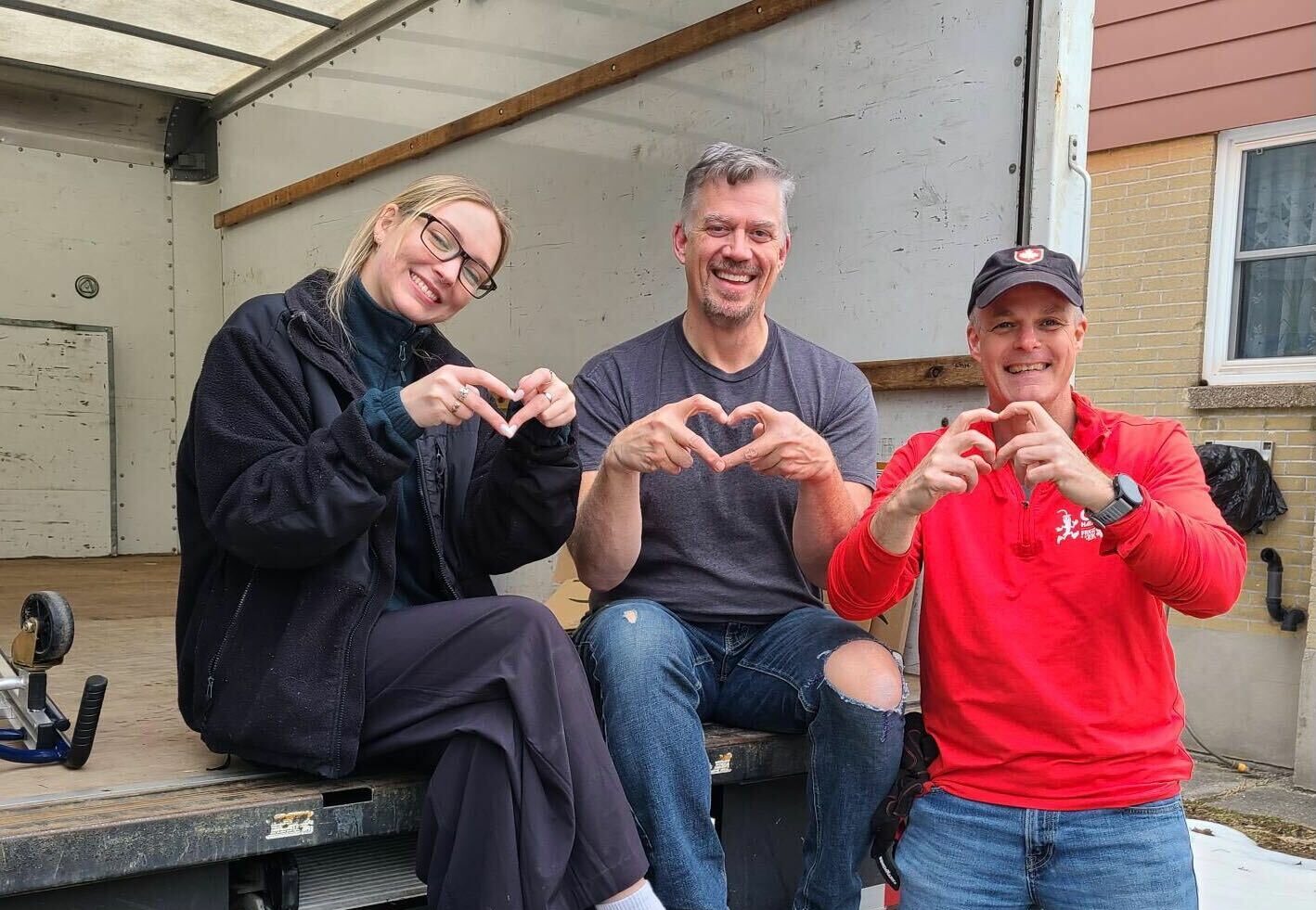 People smiling beside a moving truck
