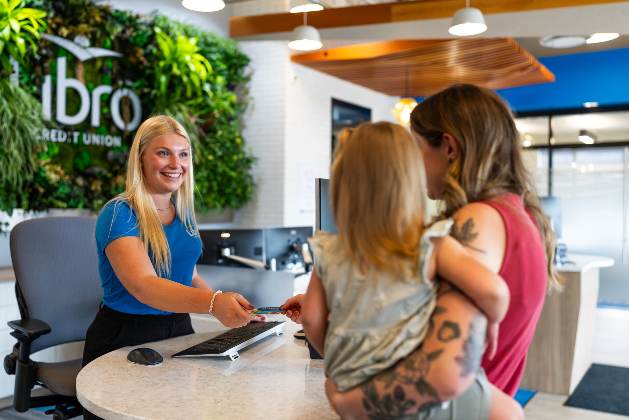 Libro Staff member at a Libro location handing a Libro card to a Libro Owner