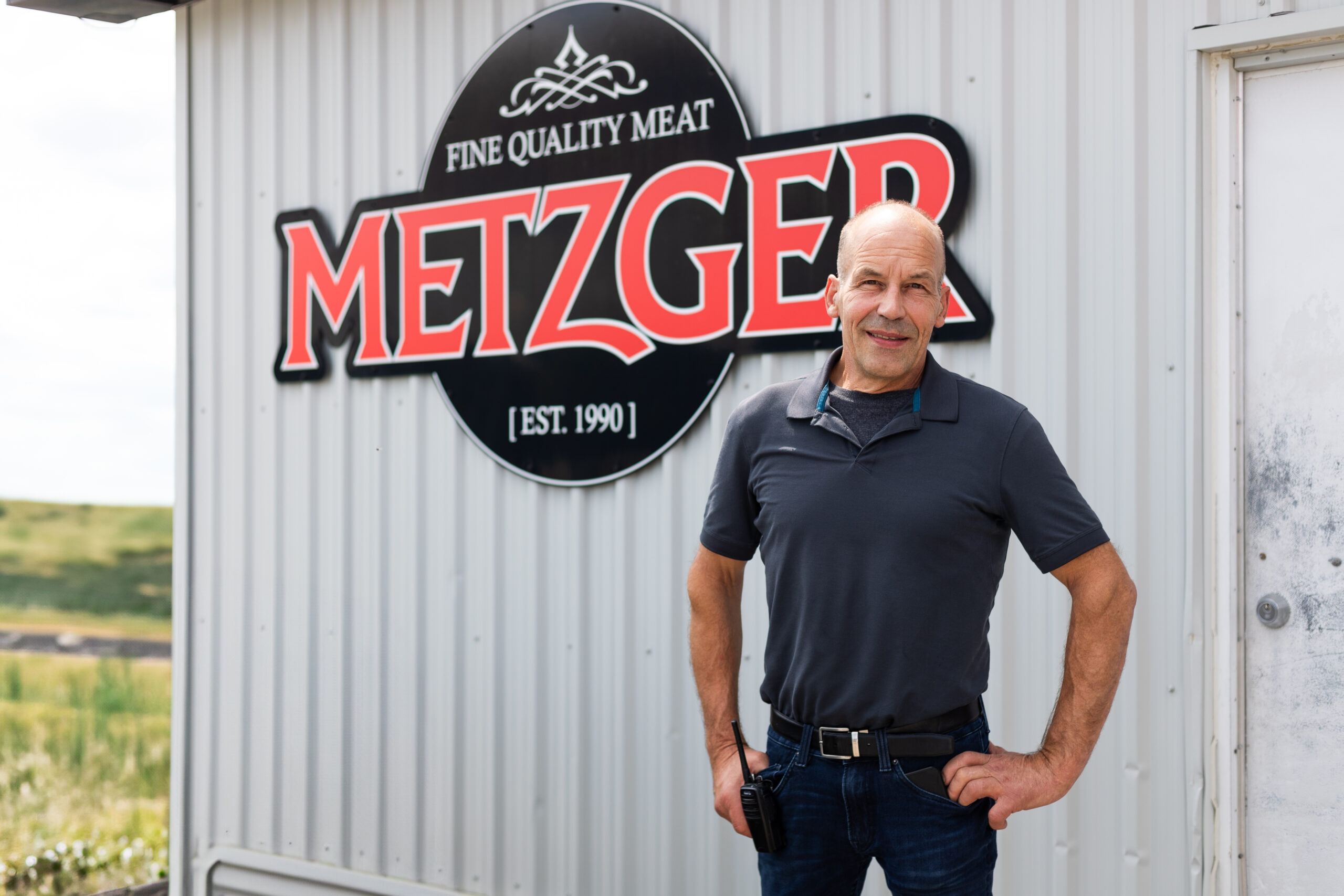 A man stands in front of a building with a large 