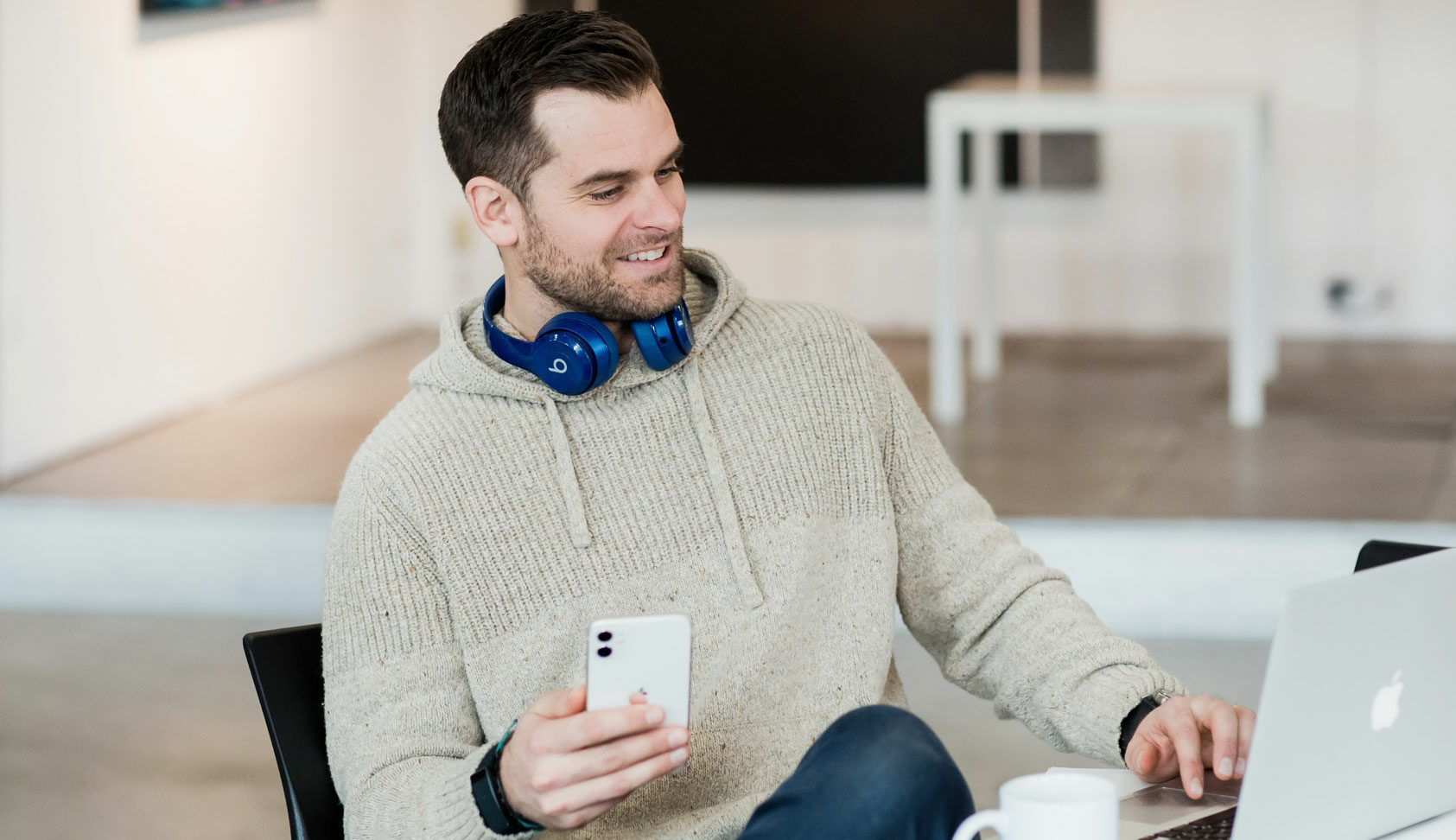 A Libro Owner holding his phone and looking at his laptop